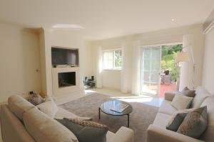 een woonkamer met een bank en een tv bij Villa Casa da Luz, Palmyra 173 - Clever Details in Vilamoura