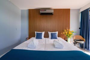 a bedroom with a large bed with blue and white pillows at Kurort Kameralny in Mikołajki
