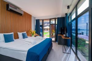 a bedroom with a large bed and a large window at Kurort Kameralny in Mikołajki