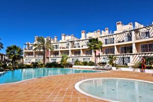 een groot gebouw met een zwembad voor een gebouw bij Villa Casa da Luz, Palmyra 173 - Clever Details in Vilamoura