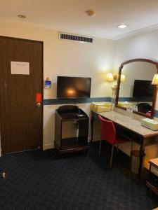 una camera d'albergo con scrivania e specchio di Guang Haw Hotel a Tainan