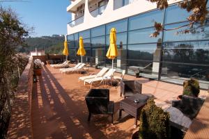 un patio con sedie e ombrelloni di fronte a un edificio di Egnatia City Hotel & Spa a Kavala
