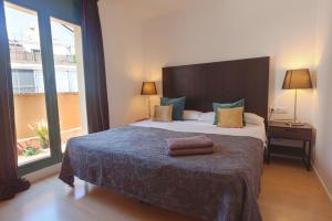 a bedroom with a large bed with a large window at Plaza Catalunya City Center Apartments in Barcelona