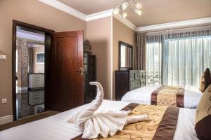 Mountain Resort Residences في زديار: غرفه فندقيه سريرين و بجعه على السرير