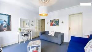 ein Wohnzimmer mit einem blauen Sofa und einem Tisch in der Unterkunft Bairro Alto - 4 Bedroom Apartment in Lissabon