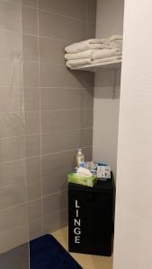 łazienka z czarną toaletką i ręcznikami na półce w obiekcie GITE DE KRAOU-KERGUELEN w mieście Larmor-Plage