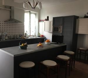a kitchen with a counter with stools and a counter top at Portale dei Soli - Room & Breakfast in Rolo
