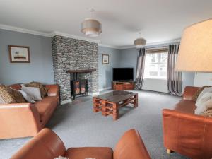 a living room with couches and a fireplace at The Bothy in Mainsriddle