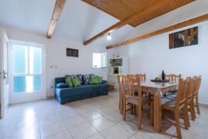 a living room with a table and a blue couch at Holiday Home Liberan in Vela Luka
