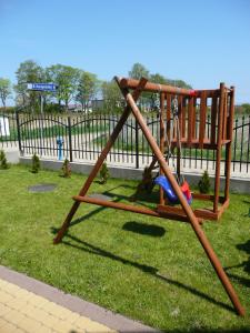 a swing set on the grass in a park at Sand Residence - Pokoje i Apartamenty in Władysławowo