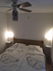 a bedroom with a bed with a ceiling fan at Bungalow Veluwemeer in Ermelo