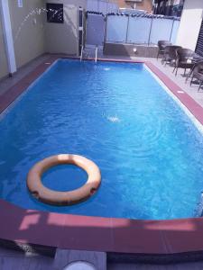 a swimming pool with a wooden ring in the water at Alluring View Hotel - Toyin Sreet in Ikeja
