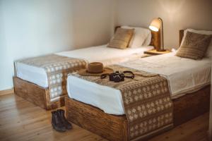 2 camas con reposapiés con sombreros en una habitación en Lost Ridge Inn, Brewery & Ranch en Sighnaghi