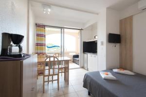 une chambre avec un lit et une cuisine avec une table dans l'établissement Appart'Hôtel Agathea, au Cap d'Agde