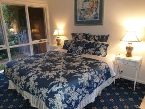 a bedroom with a blue and white bed and a window at Race Course Apartments in Yarra Glen