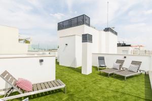 patio z krzesłami i trawą na dachu w obiekcie Feelathome Goya Apartments w Madrycie