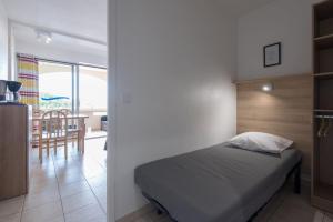 - une chambre avec un lit et une salle à manger dans l'établissement Appart'Hôtel Agathea, au Cap d'Agde