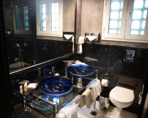 a bathroom with a blue sink and a toilet at Andromeda Suites in Athens