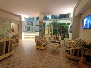 eine Lobby mit Stühlen und einem TV in einem Gebäude in der Unterkunft Crystal Hotel Varese in Varese
