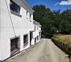 polna droga obok białego budynku w obiekcie Complejo Apartamentos Rurales Molino de Abajo w mieście Ribera Baja