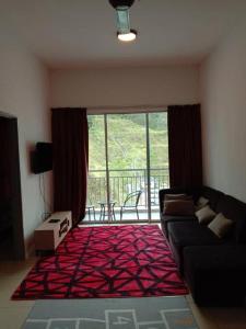 a living room with a couch and a large window at Galina Somersquare Goldenhills Aprt Pasar Malam Cameron Highlands in Brinchang