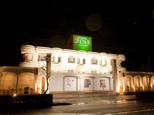 a white building with a green sign on top of it at Hotel Fine Garden Suzuka in Suzuka