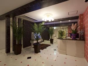 a lobby with potted plants in the middle of a room at Hotel Fine Garden Suzuka in Suzuka