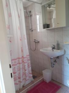 y baño con cortina de ducha y lavamanos. en Apartments Boglić, en Umag