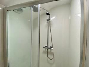 a shower with a glass door in a bathroom at Southernwood - Garden Lodge 14 in Didcot