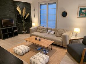 a living room with a couch and a table at Appartement familial plein centre Hardelot Plage in Hardelot-Plage