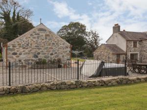 Y Deri Cottage في Llandwrog: سور أمام منزل حجري