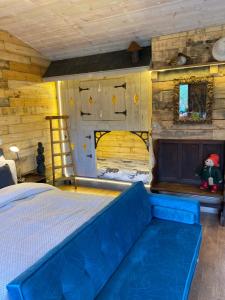 a bedroom with a blue couch in a room at Willow Court Farm Studio East & Petting Farm, 8 mins to Legoland & Windsor, 15 mins to Lapland UK in Windsor