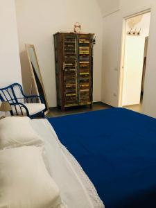 1 dormitorio con 1 cama azul y vestidor en Zì Marì - Via Sirene en Polignano a Mare