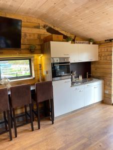 uma cozinha com armários brancos e uma mesa com cadeiras em Willow Court Farm Studio East & Petting Farm, 8 mins to Legoland & Windsor, 15 mins to Lapland UK em Windsor