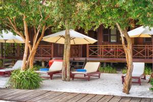 a patio area with chairs, tables and umbrellas at Sok San Beach Resort in Koh Rong Island