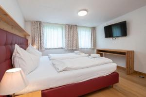 sypialnia z dwoma łóżkami i telewizorem z płaskim ekranem w obiekcie Chalet Schmittenbach - Pinzgau Holidays w mieście Zell am See