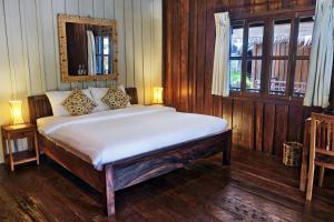 a bedroom with a bed with white sheets and a window at Sok San Beach Resort in Koh Rong Island