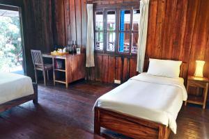 a bedroom with two beds and a table and a window at Sok San Beach Resort in Koh Rong Island