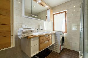 łazienka z umywalką i pralką w obiekcie Chalet Schmittenbach - Pinzgau Holidays w mieście Zell am See +29 zdjęć