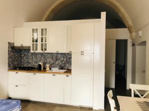 a kitchen with white cabinets and a sink at Zì Marì - Via Sirene in Polignano a Mare