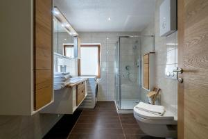 łazienka z toaletą i przeszklonym prysznicem w obiekcie Chalet Schmittenbach - Pinzgau Holidays w mieście Zell am See
