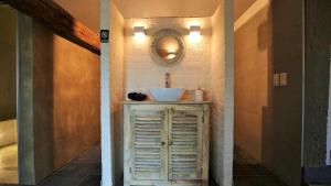 Authentic wellnesshoeve في Hansbeke: حمام مع حوض ومرآة على الحائط
