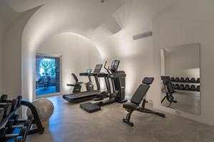 a gym with several tread machines and a mirror at Bellevue Syrene in Sorrento