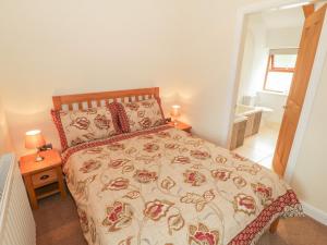 LlandwrogにあるY Beudy Cottageのベッドルーム1室(ベッド1台付)、バスルーム(窓付)が備わります。