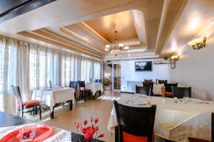 - un restaurant avec des tables et des chaises dans une salle dans l'établissement Vila Palace, à Caransebeş