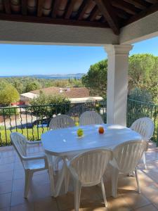 una mesa blanca y sillas blancas en el patio en Appartement Les Restanques du Golfe de Saint-Tropez, en Grimaud