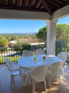 a white table and white chairs on a patio at Appartement Les Restanques du Golfe de Saint-Tropez in Grimaud