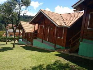 un par de pequeños edificios de madera en un patio en Chalés Eucaliptos -Recanto da Neusa-, en Monte Verde 9 fotos más