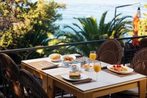 a table with food and drinks on a balcony at Hotel Podstine in Hvar