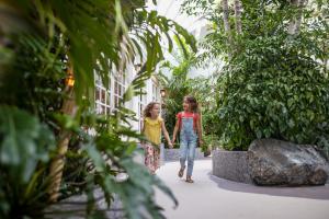 dos niñas caminando por un jardín en Center Parcs Zandvoort beach, en Zandvoort